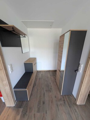 A room with a built-in bench, a wardrobe with a mirror, and a light fixture on the ceiling. - Stauseeblick Vacation Rental in Wiedersbach (Auengrund)