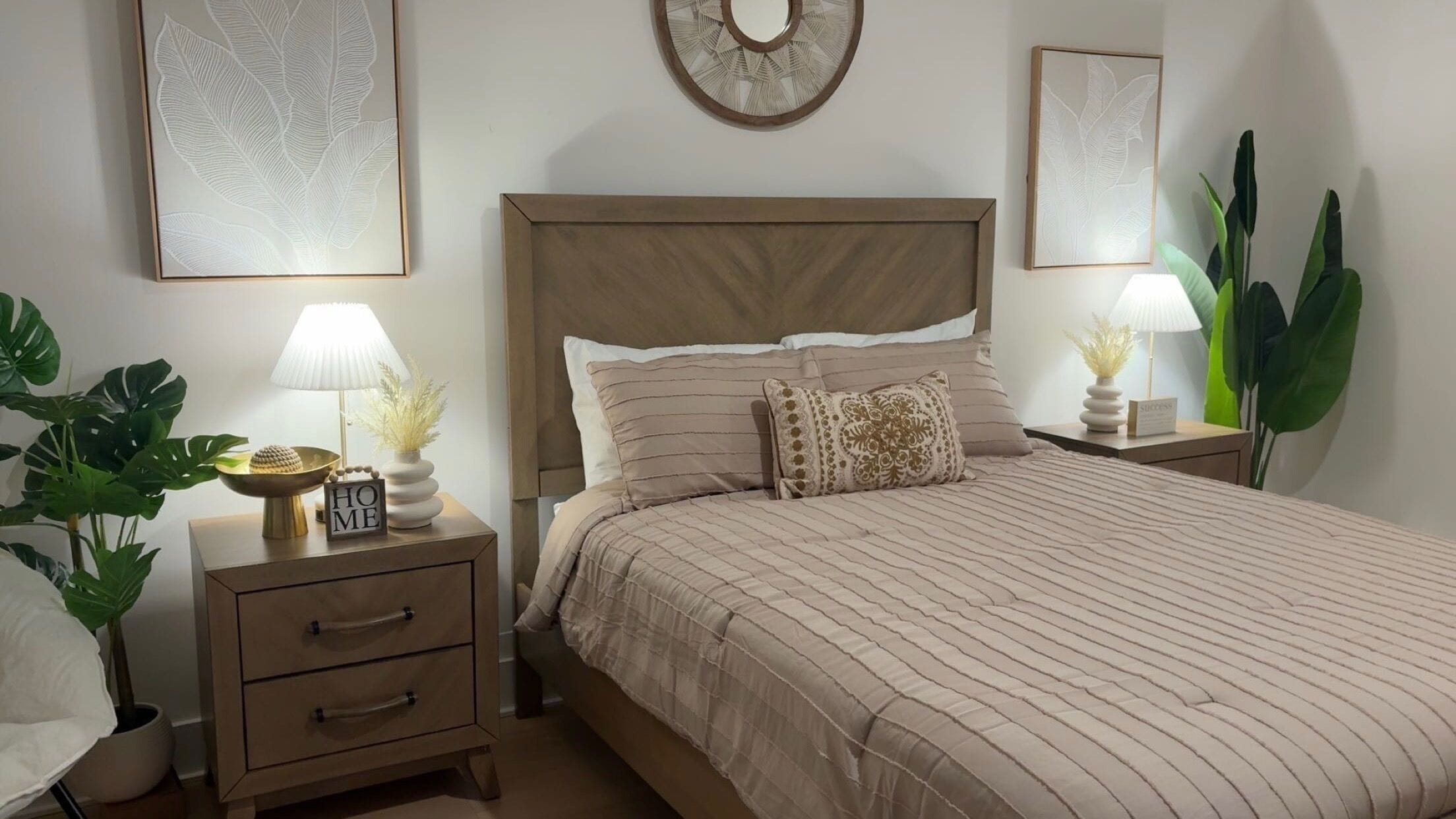 A bedroom with a bed, nightstands, a lamp, and a potted plant.