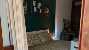 Una camera da letto con un letto, un comodino, una lampada e due piante in vaso.