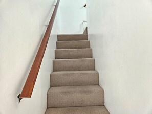 A staircase with a wooden handrail and carpeted steps. - Bright 2 Bed Venice Loft (Los Angeles)