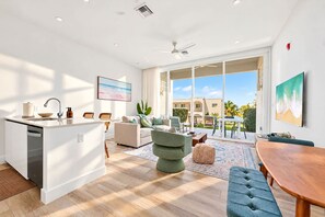 Ein modernes Wohnzimmer mit Küche, Essbereich und einem Balkon mit Blick.