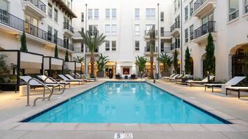 A pool area with lounge chairs and a fire feature in the center.
