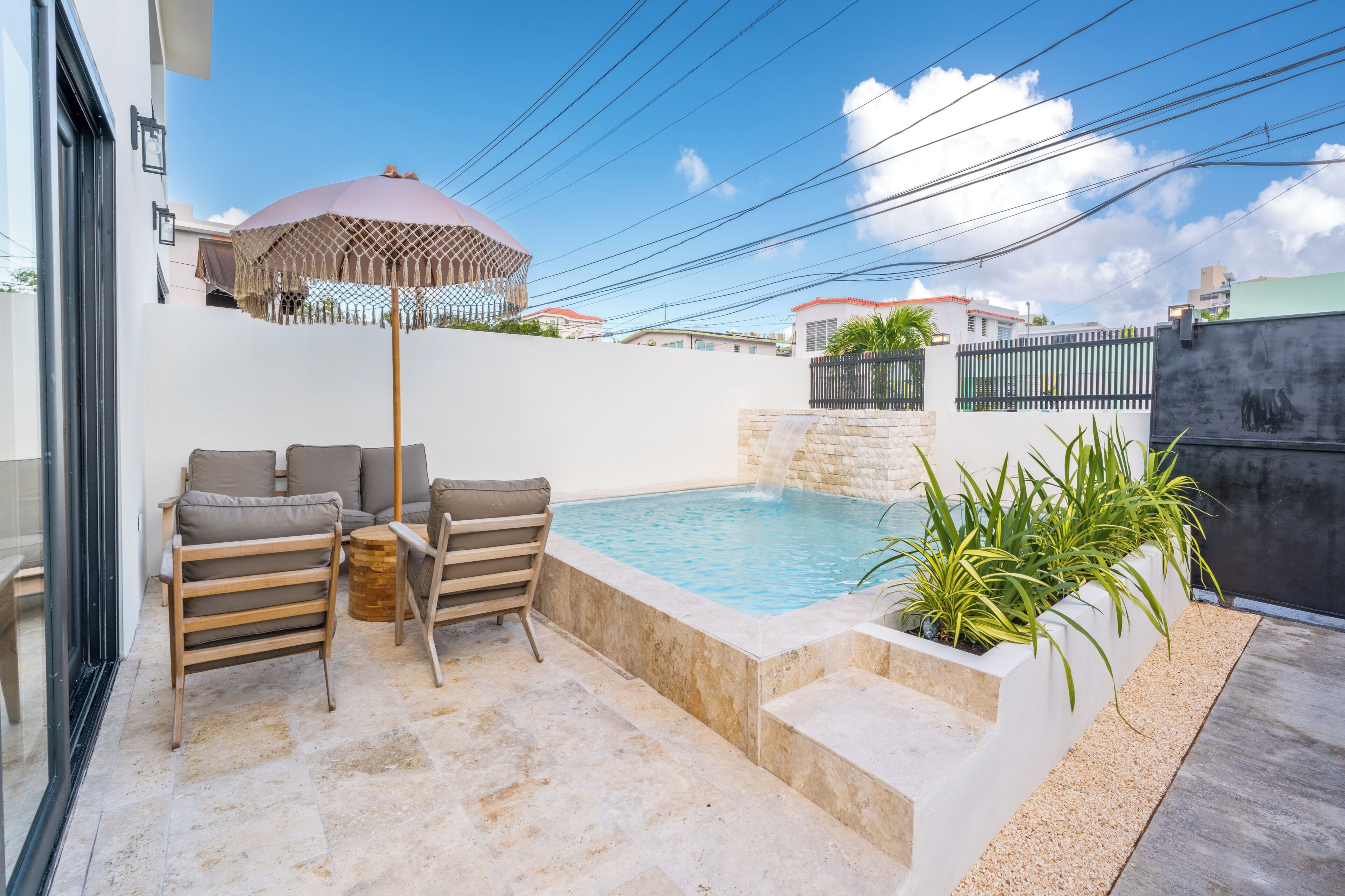 A pool area with a seating arrangement and a water feature.