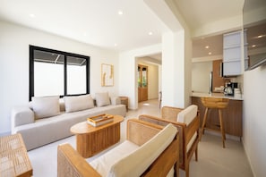 A modern living room with a sofa, a coffee table, and wicker chairs. - 5BR Private Pool  Sleeps 10 Walk to Ocean Park Beach (San Juan)