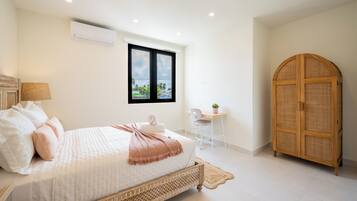 A bedroom with a bed, a desk, a chair, a wardrobe, and a window with a view.