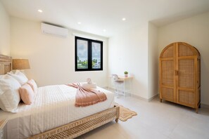 A bedroom with a bed, a desk, a chair, a wardrobe, and a window with a view.