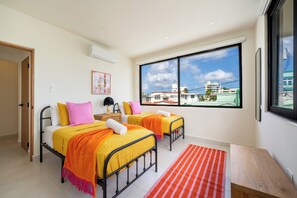 A hotel room with two beds, a large window, and a view of buildings outside. - 5BR Private Pool Retreat Walk to Ocean Park Beach (San Juan)