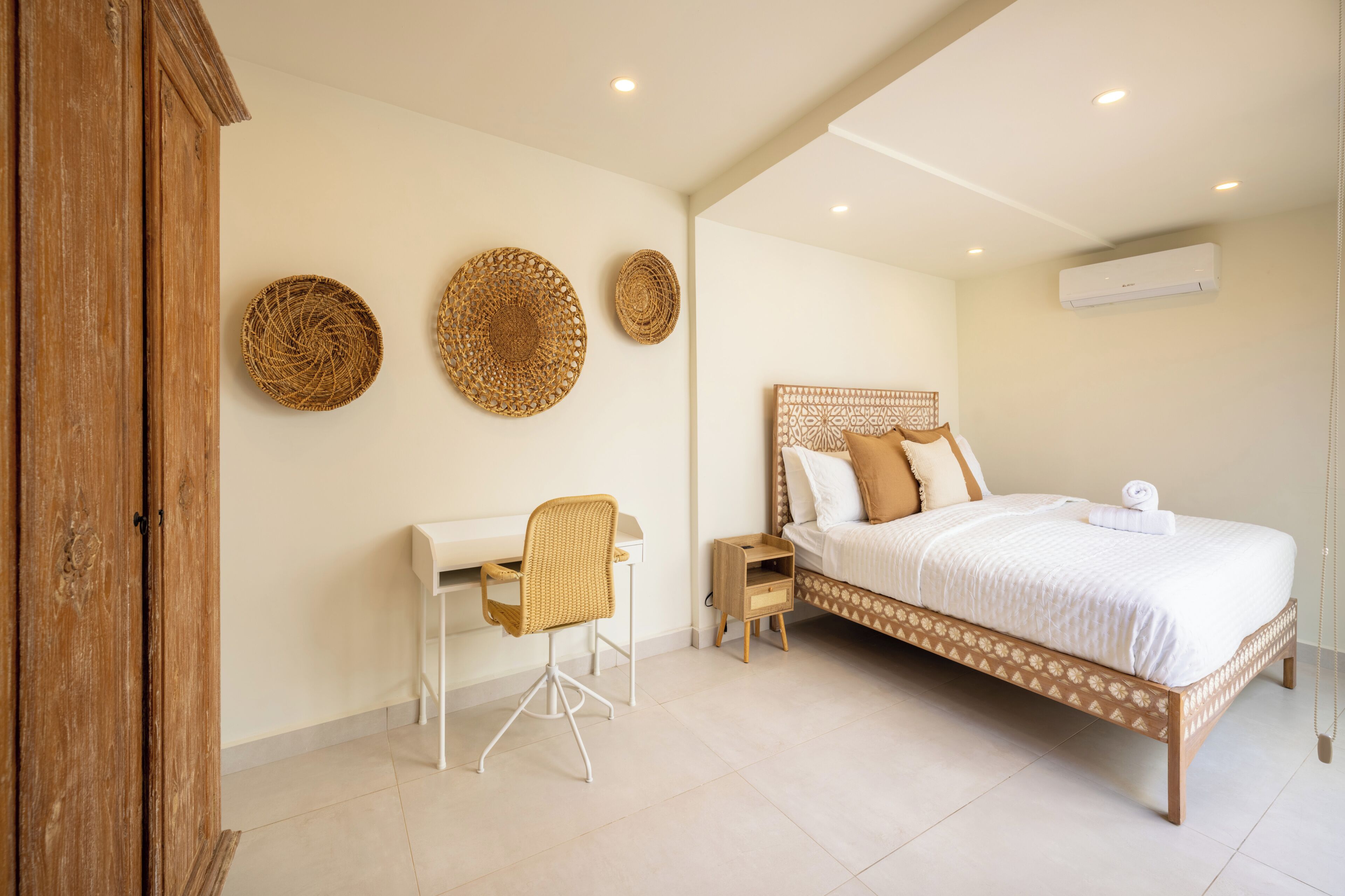 A bedroom with a bed, a desk, and a chair.