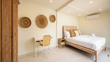 A bedroom with a bed, a desk, and a chair.