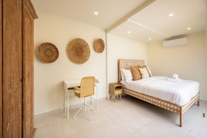 Een slaapkamer met een bed, een bureau en een stoel.