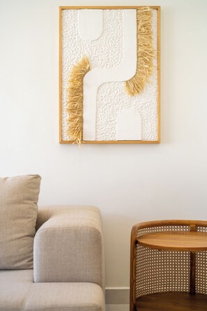 A room with a beige sofa, a wooden dining table, and a wall-mounted artwork. - 5BR Private Pool Retreat Walk to Ocean Park Beach (San Juan)
