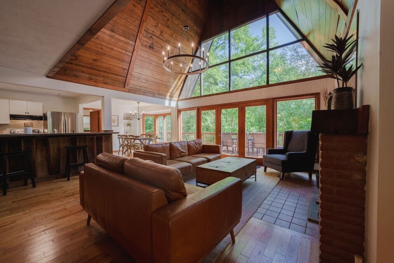 A spacious living area with a high ceiling, a dining table, and a kitchen area.