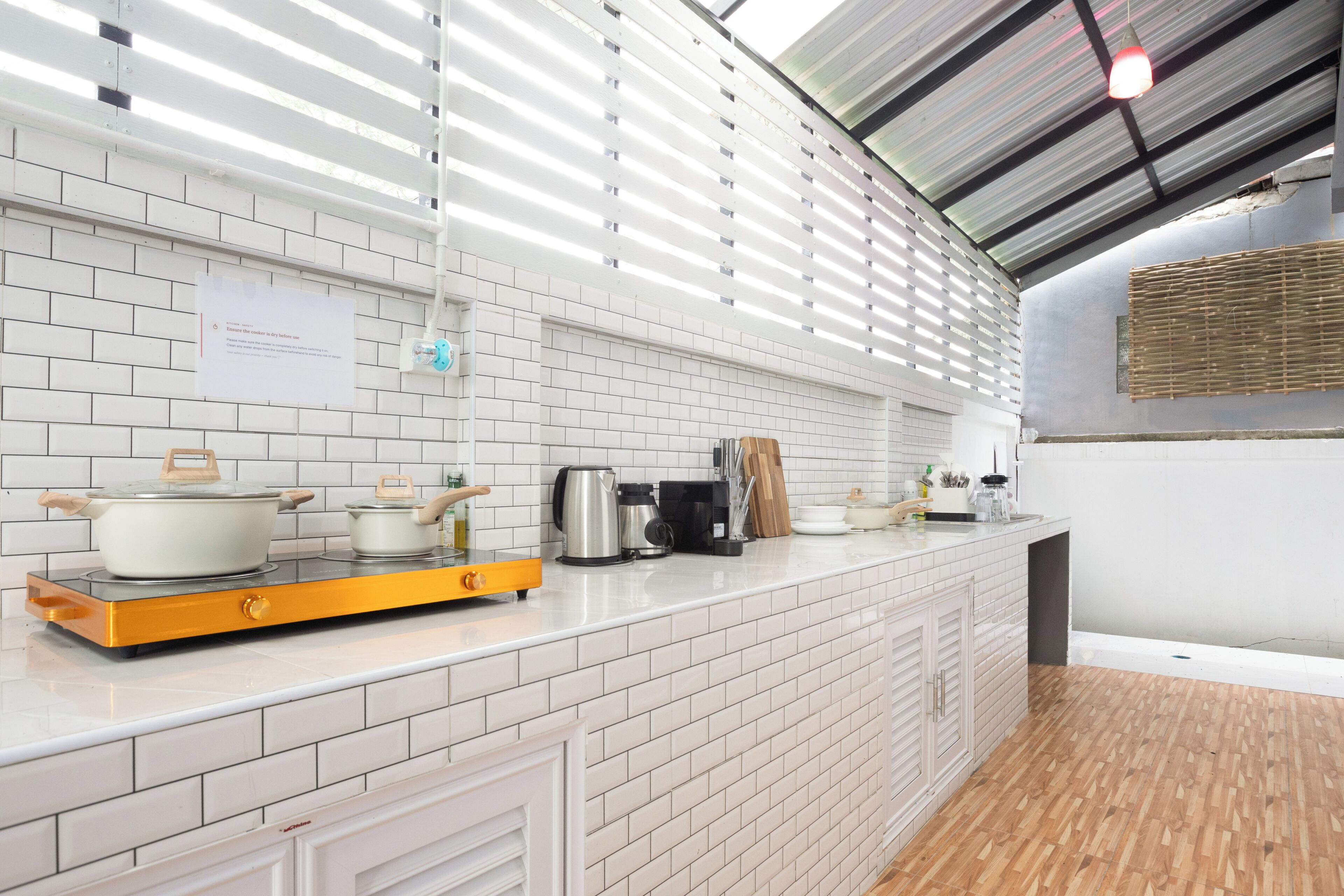 A modern kitchen with white subway tiles, a wooden countertop, and a stainless steel range hood.