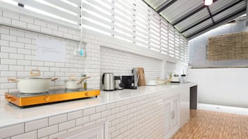 A modern kitchen with white subway tiles, a wooden countertop, and a stainless steel range hood.