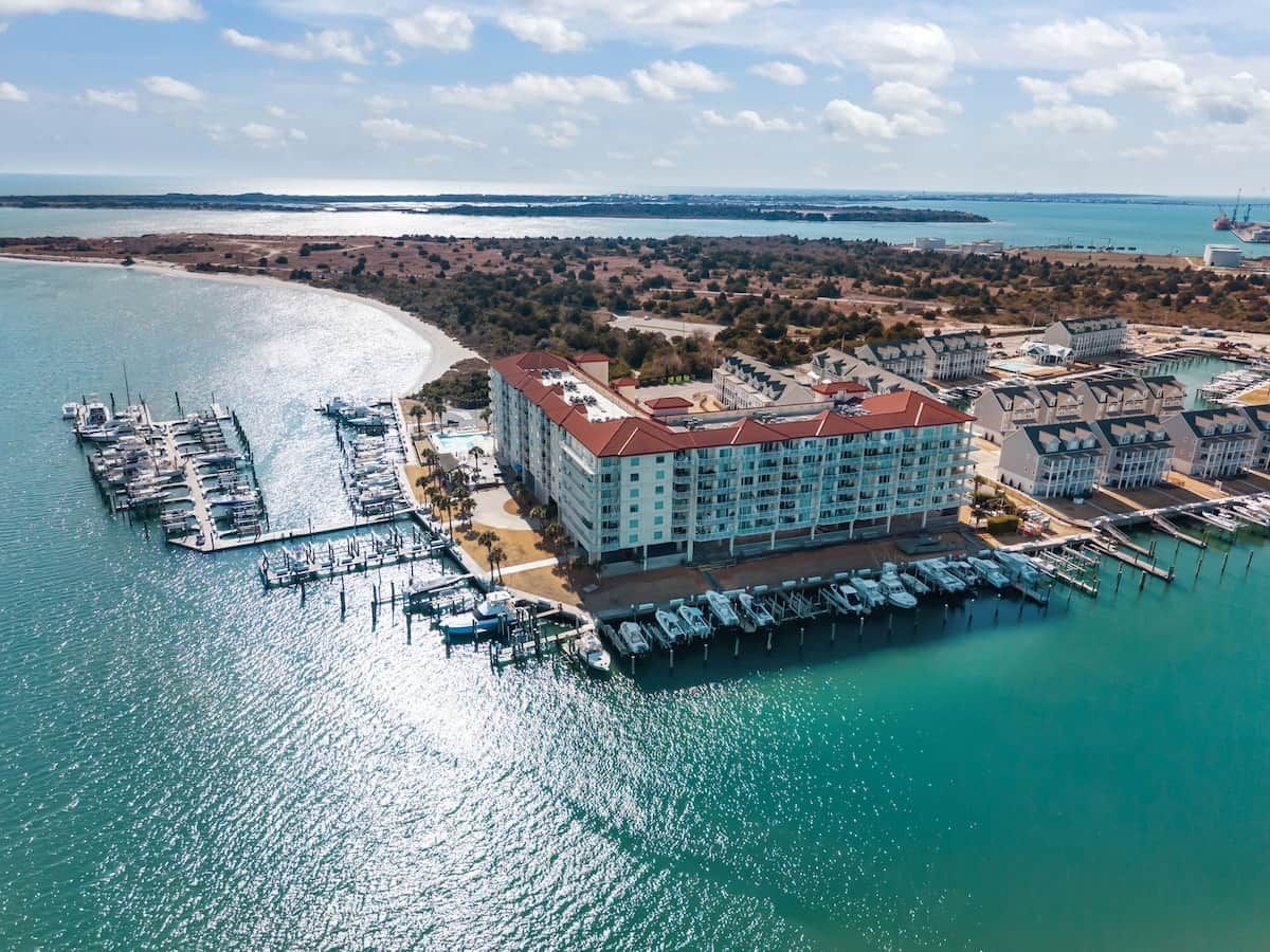 Un hotel frente al mar con puerto deportivo, varias terrazas y vistas al océano.