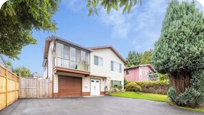 A two-story house with a garage, a driveway, and a well-maintained lawn. - Spacious 3BR/2BA Family Home in Delta | Sleeps 12 (Delta)