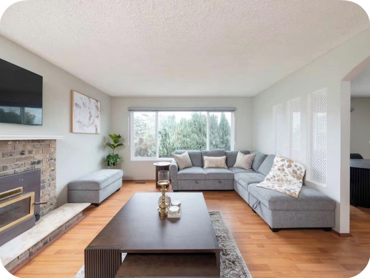 Ein modernes Wohnzimmer mit Kamin, grauem Sofa und Couchtisch.