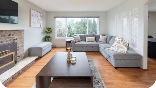 A modern living room with a fireplace, grey sofa, and a coffee table. - Spacious 3BR/2BA Family Home in Delta | Sleeps 12 (Delta)