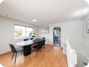 A modern dining area with a round table, black chairs, and a vase of flowers. - Spacious 3BR/2BA Family Home in Delta | Sleeps 12 (Delta)