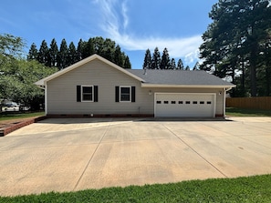 A single-story house with a garage, a driveway, and a lawn.