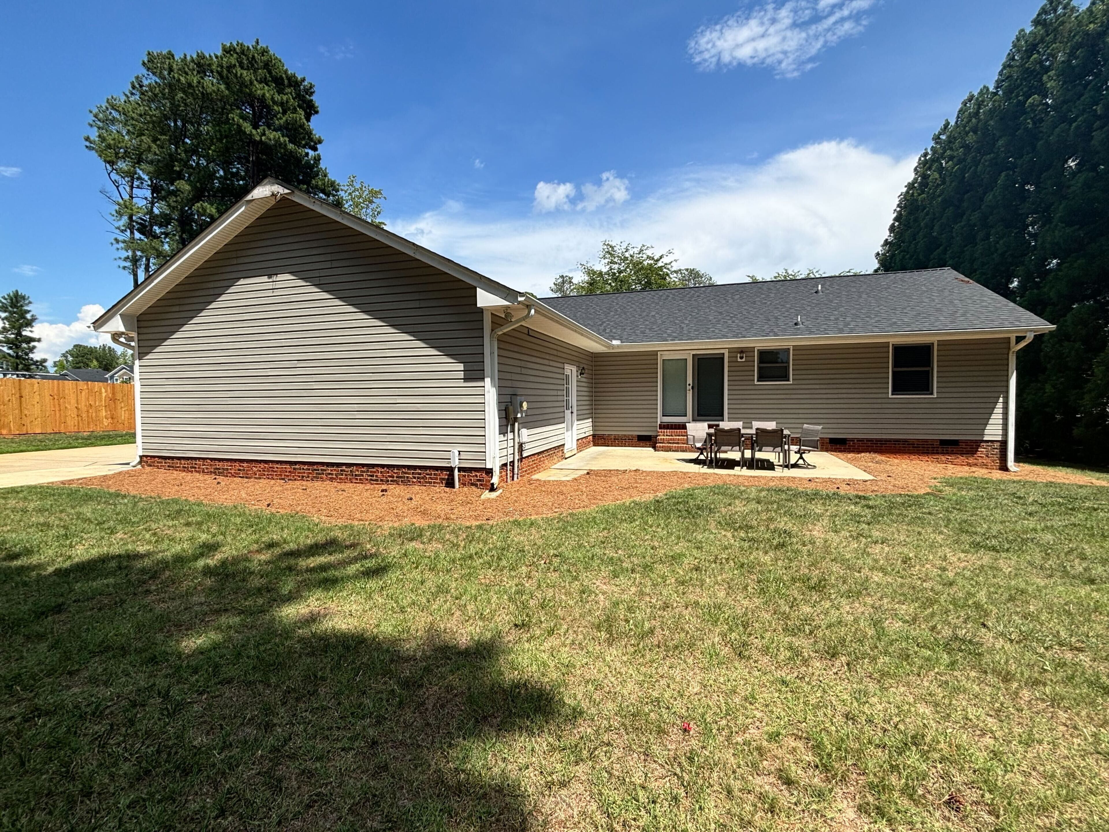 A single-story house with a covered patio area and a small deck.