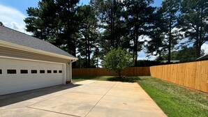 A residential garage with a concrete driveway leading to a grassy yard.