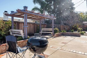 A barbecue grill, two chairs, and a wooden pergola in a backyard. - Spacious 4-Bedroom Single-Story Home in Brentwood (Brentwood)