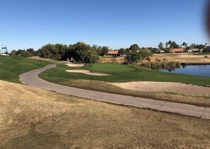 A golf course with a curved pathway, a pond, and residential buildings in the background. - "The Loft"-  Modern Scottsdale Villa 
  Golf-Course   Pool + Gym (Scottsdale)