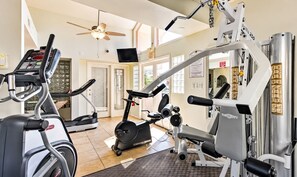 A gym with cardio machines, weight training equipment, and a ceiling fan. - "The Loft"-  Modern Scottsdale Villa 
  Golf-Course   Pool + Gym (Scottsdale)