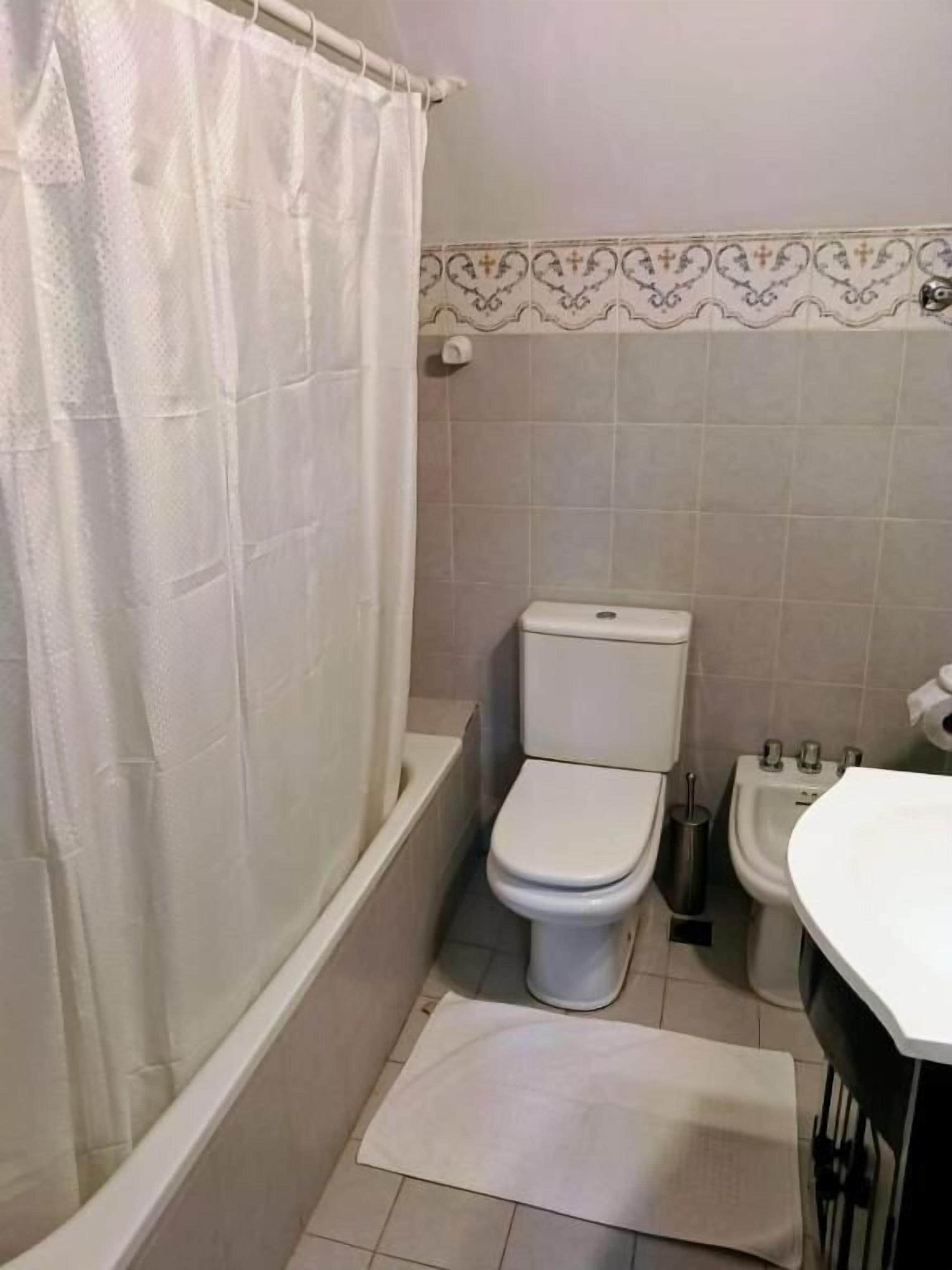 Un baño con bañera, inodoro, bidé y lavamanos.
