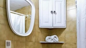 A bathroom with a white sink, a mirror, a towel rack, and a cabinet. - Apart Rose Garden (San Martin de los Andes)