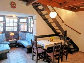 Un comedor con una mesa y sillas, un sofá y una escalera.