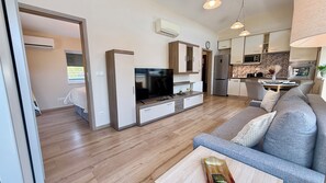 Een moderne woonkamer met een flatscreen televisie, een bank en een salontafel.