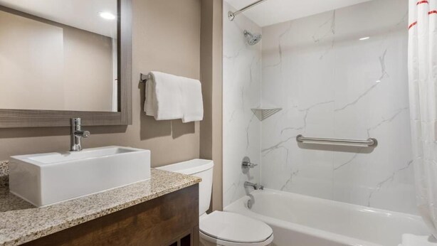 A bathroom with a sink, toilet, and bathtub.