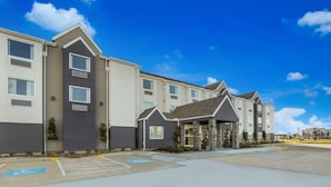 A multi-story hotel with a parking lot and a covered entrance.