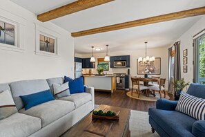 Ein modernes Wohnzimmer mit einer Couch, einem Couchtisch und einem Essbereich mit Stühlen und einem Tisch.