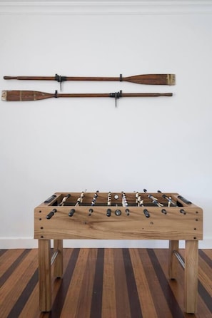 A wooden foosball table with a classic design, positioned against a plain wall. - Willow Landing Beach House with Private Jetty (Frankston)
