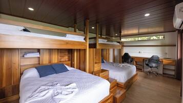 A room with bunk beds, a desk, and a chair.