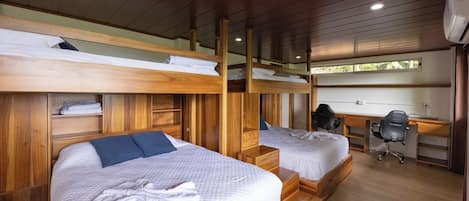 A room with bunk beds, a desk, and a chair.