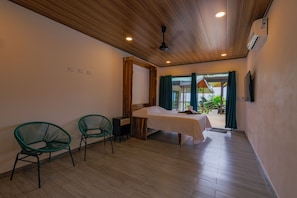 A bedroom with a bed, two chairs, a wooden ceiling, and a view of the outdoors. - Casa Odi-Sea 2.0 (Savegre)
