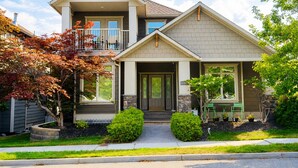 A two-story residential house with a front porch, a garage, and a visible address number.