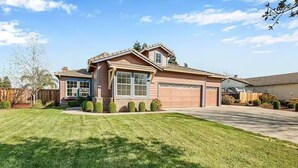 A two-story house with a garage, a well-maintained lawn, and a clear sky. - home away from home spacious 3b 2b mobile home covered back porch with hot tub.. (seven points)