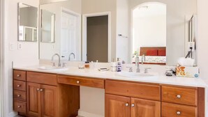 A bathroom with two sinks, wooden cabinets, and a large mirror. - home away from home spacious 3b 2b mobile home covered back porch with hot tub.. (seven points)