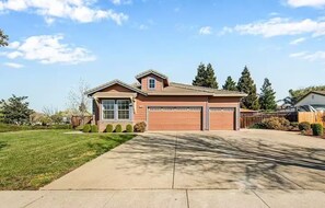 A two-story house with a garage, a front lawn, and a clear sky.