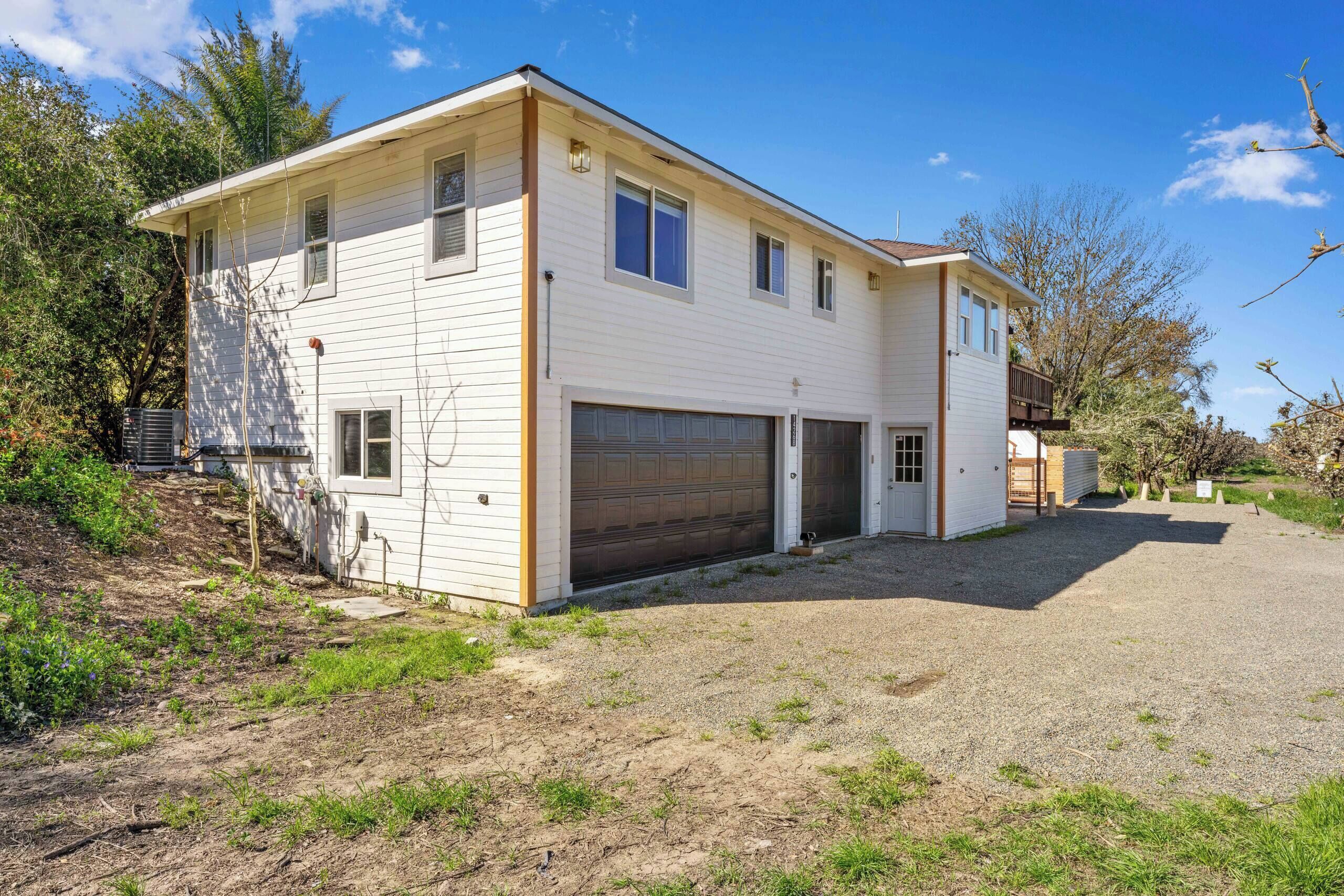 A two-story house with a garage and a covered driveway.