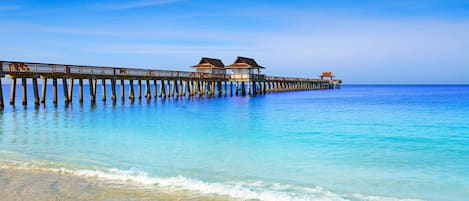 A pier extending into the ocean with overwater bungalows.