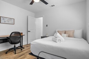 A hotel room with a bed, a desk, and a chair. - Modern Getaway & Casita Near the Domain + Fire Pit Backyard, Sleeps 8 (Austin)