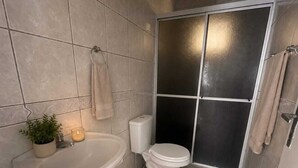 Uma casa de banho com lavatório, sanita e zona de duche.