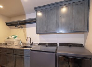 A kitchen with dark cabinets, a granite countertop, a sink, and a dishwasher. - Parkside Teton Springs Cabin in Victor, ID w/ A/C & Hot Tub (Victor)