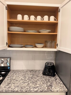 Eine Küche mit einer Granitabdeckung, einem Einbauofen und einer Kaffeemaschine.